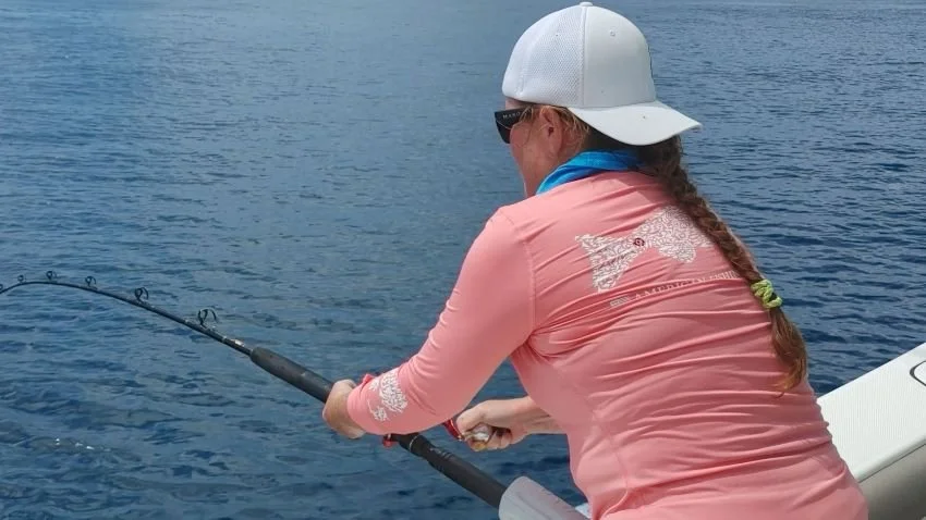 lady angler fighting a big fish on stand up gear
