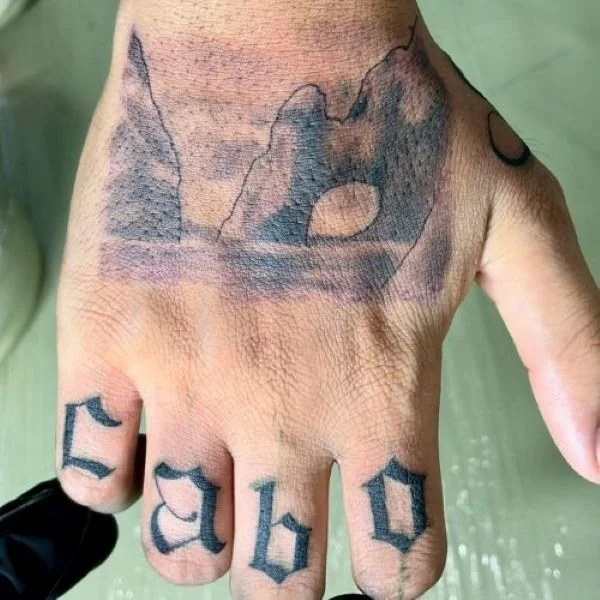 Cabo Arch Tattoo on the back of a hand with lettering