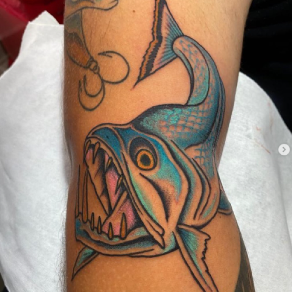 Blue and white tattoo of payara chasing a lure