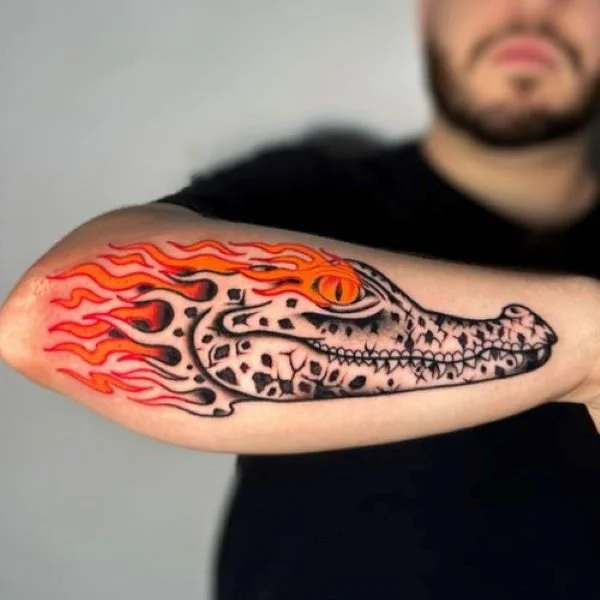 Flaming caiman head tattoo forearm