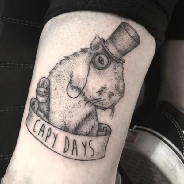 Black and white tattoo of a capybara with a top hat and a monocle