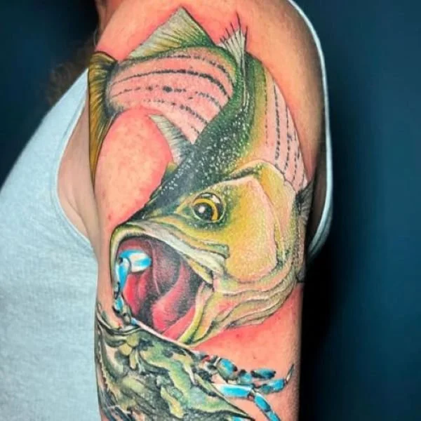 full color tattoo of a striped bass eating a blue crab