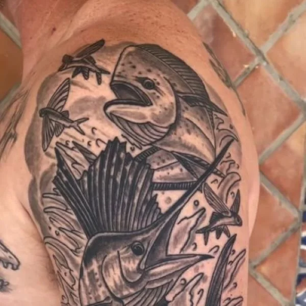 Black and white tattoo of mahi and sailfish chasing flying fish