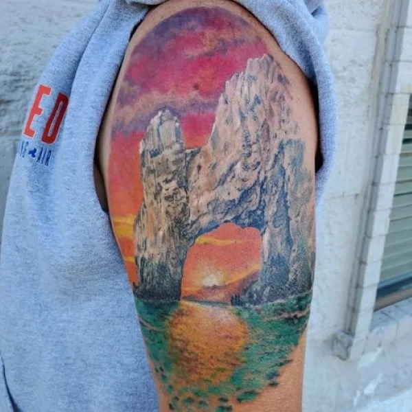 Colorful arm shoulder tattoo of Cabo Arch