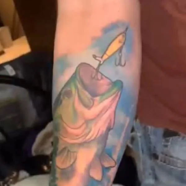 Colorful tattoo of largemouth bass chasing a Whopper Plopper