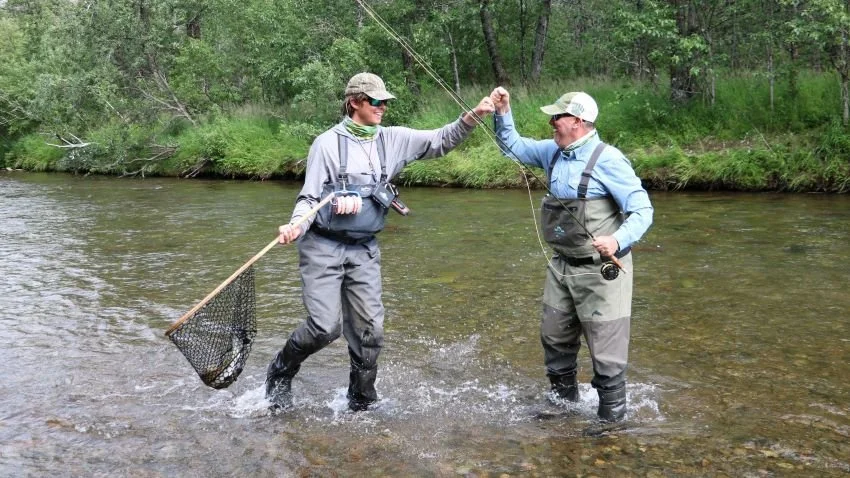 Picture of Alaska fly fishing guide fist bumping his client