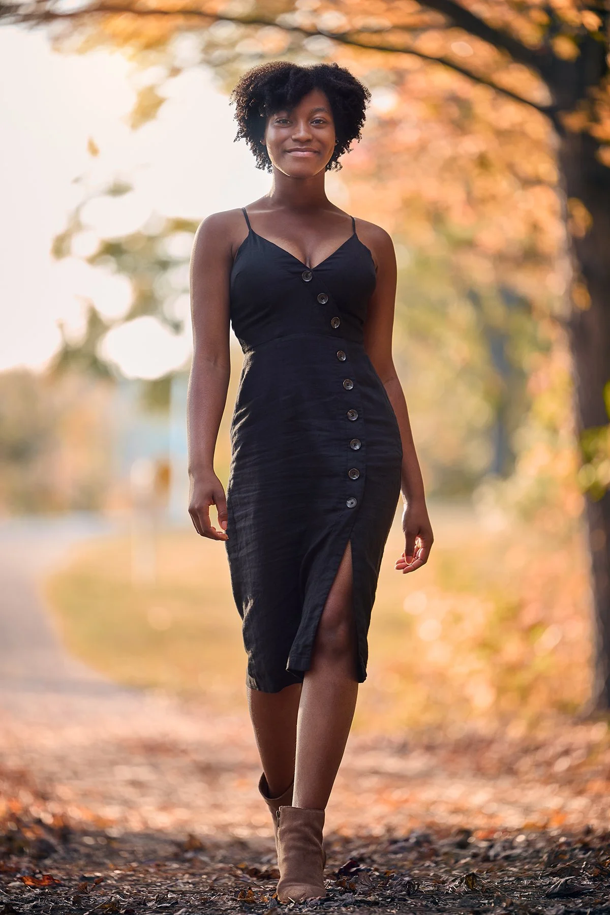 Girls senior portrait in a black dress walking outdoors at golden hour, part of a Class of 2027 senior photo session by South Atlanta Photography.