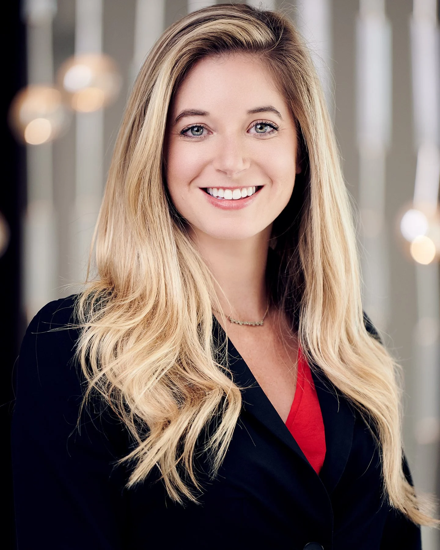 Professional individual headshot of a smiling woman in business attire photographed with a polished, approachable style for professional marketing and LinkedIn use.