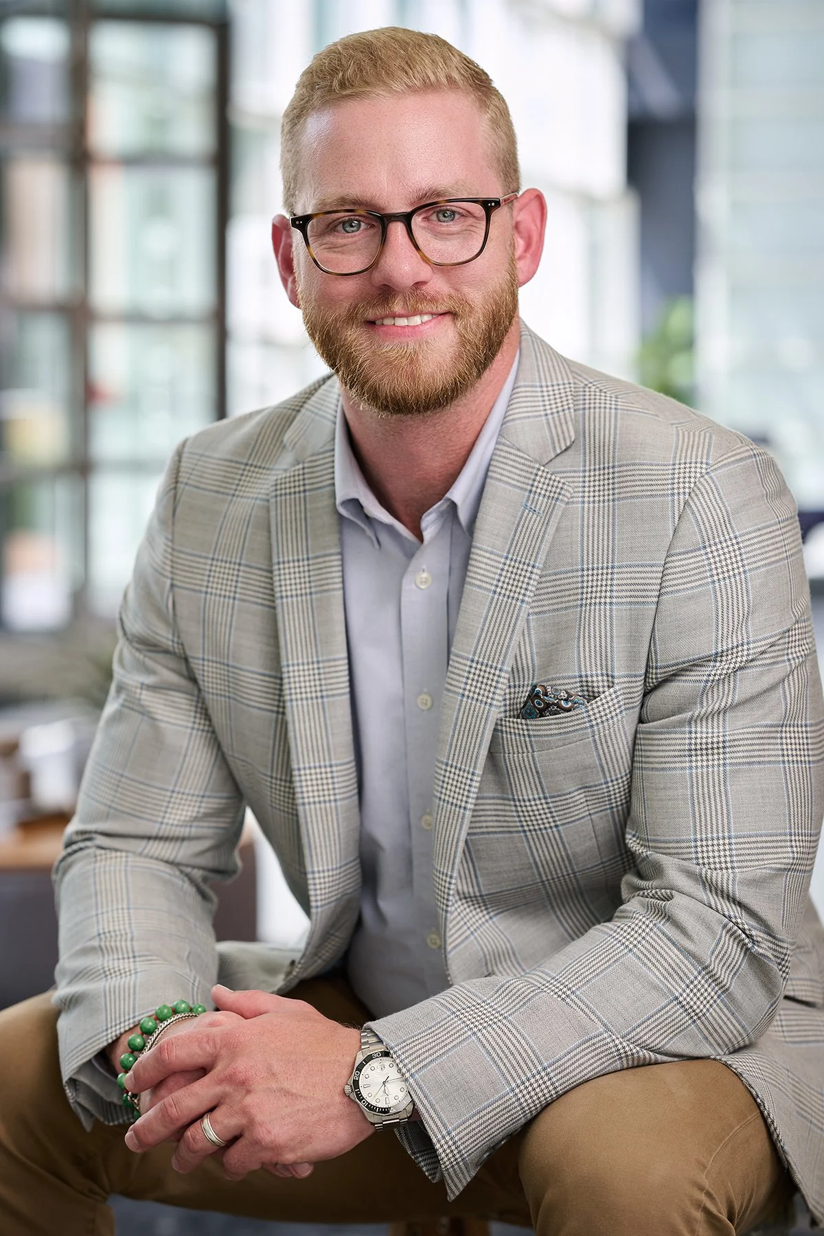 Professional environmental headshot of a male business professional in a plaid blazer, photographed in a bright modern office by South Atlanta Photography.