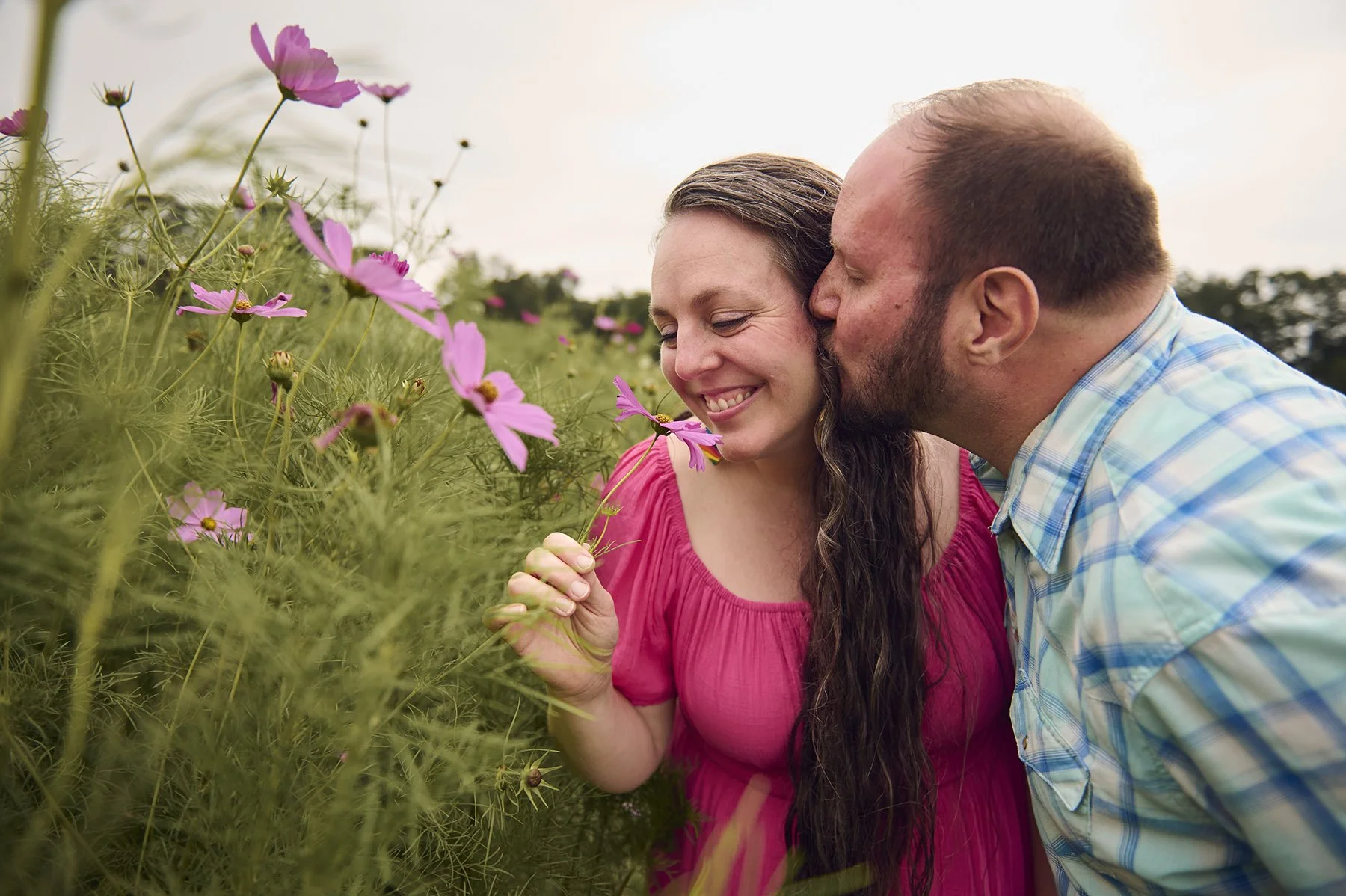 Couple photographed together in a flower field during a natural outdoor family portrait session in Peachtree City, Georgia.