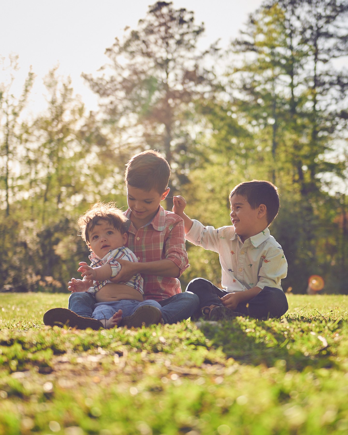 Three young brothers photographed together outdoors during a relaxed sibling and family portrait session in Peachtree City, Georgia.