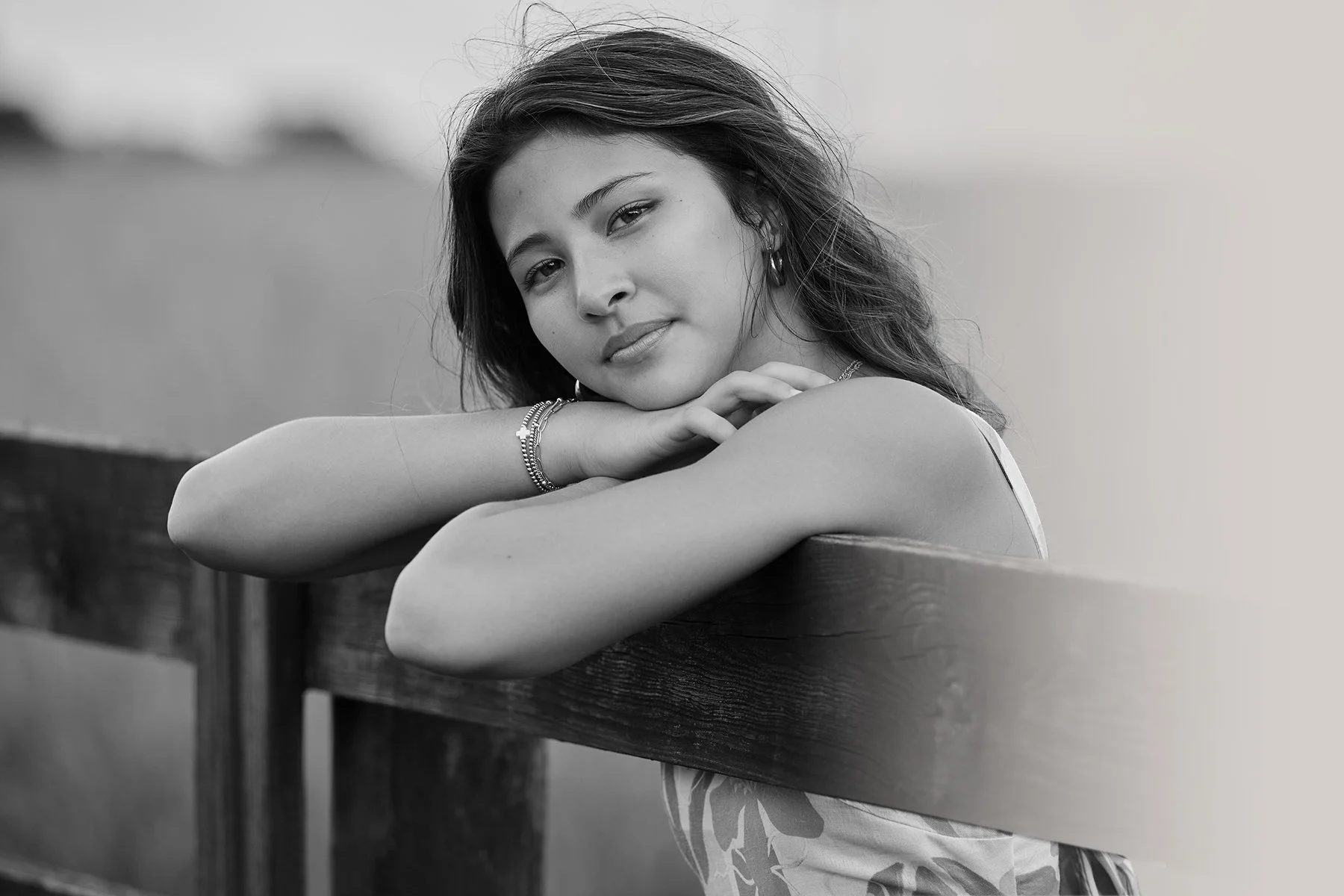 Black and white girls senior portrait leaning on a wooden fence, photographed by South Atlanta Photography for Class of 2027 senior sessions in Peachtree City and Fayette County.