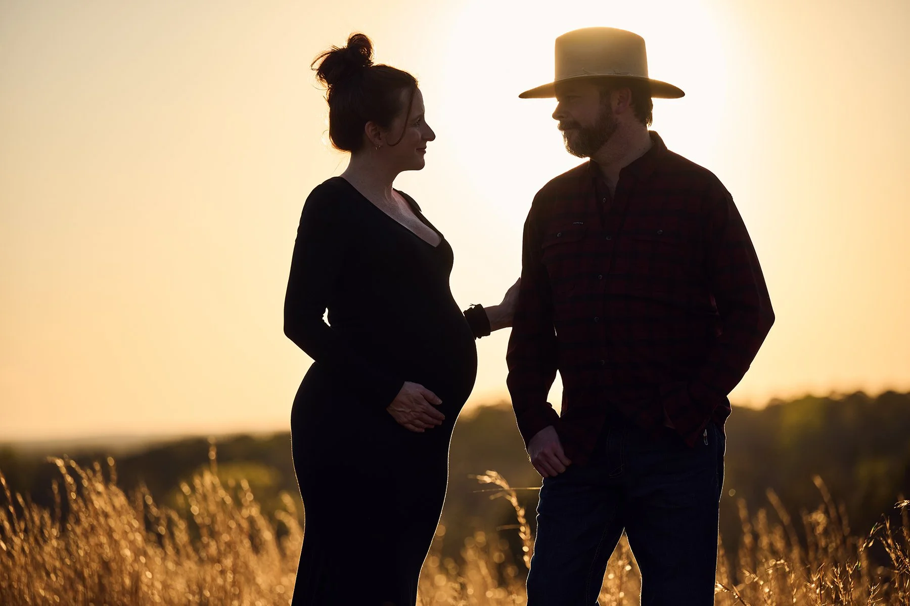 Expectant couple photographed together outdoors at sunset during a maternity and family portrait session in Peachtree City, Georgia.