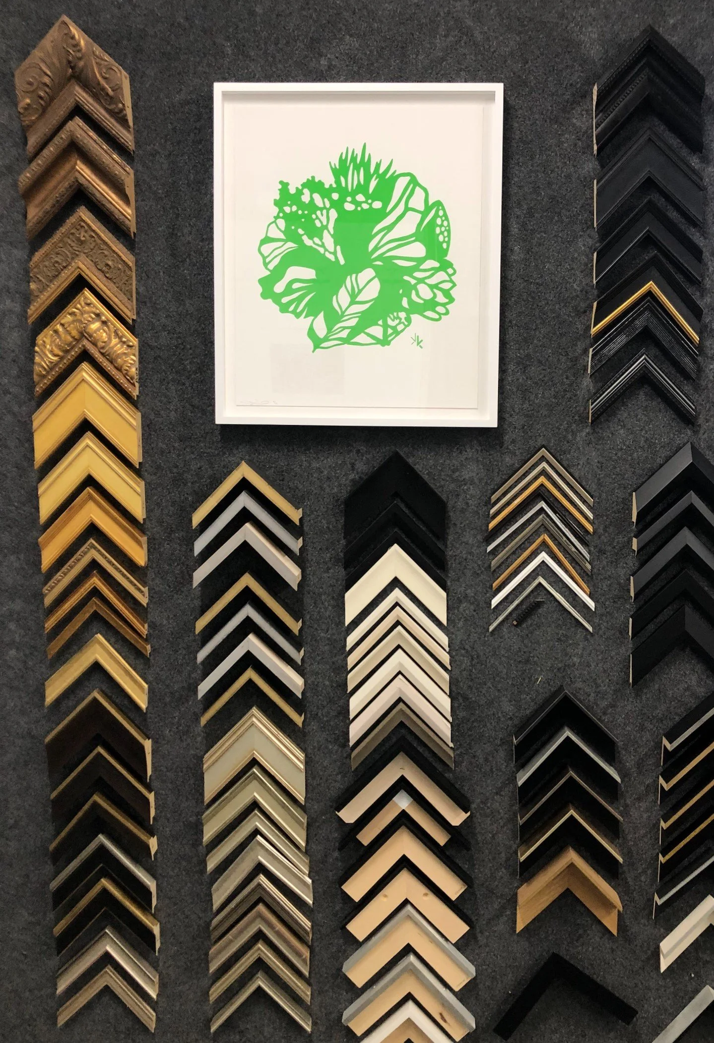 Picture of frame sample wall and a custom frame example at Artserve's NE Minneapolis frame shop.