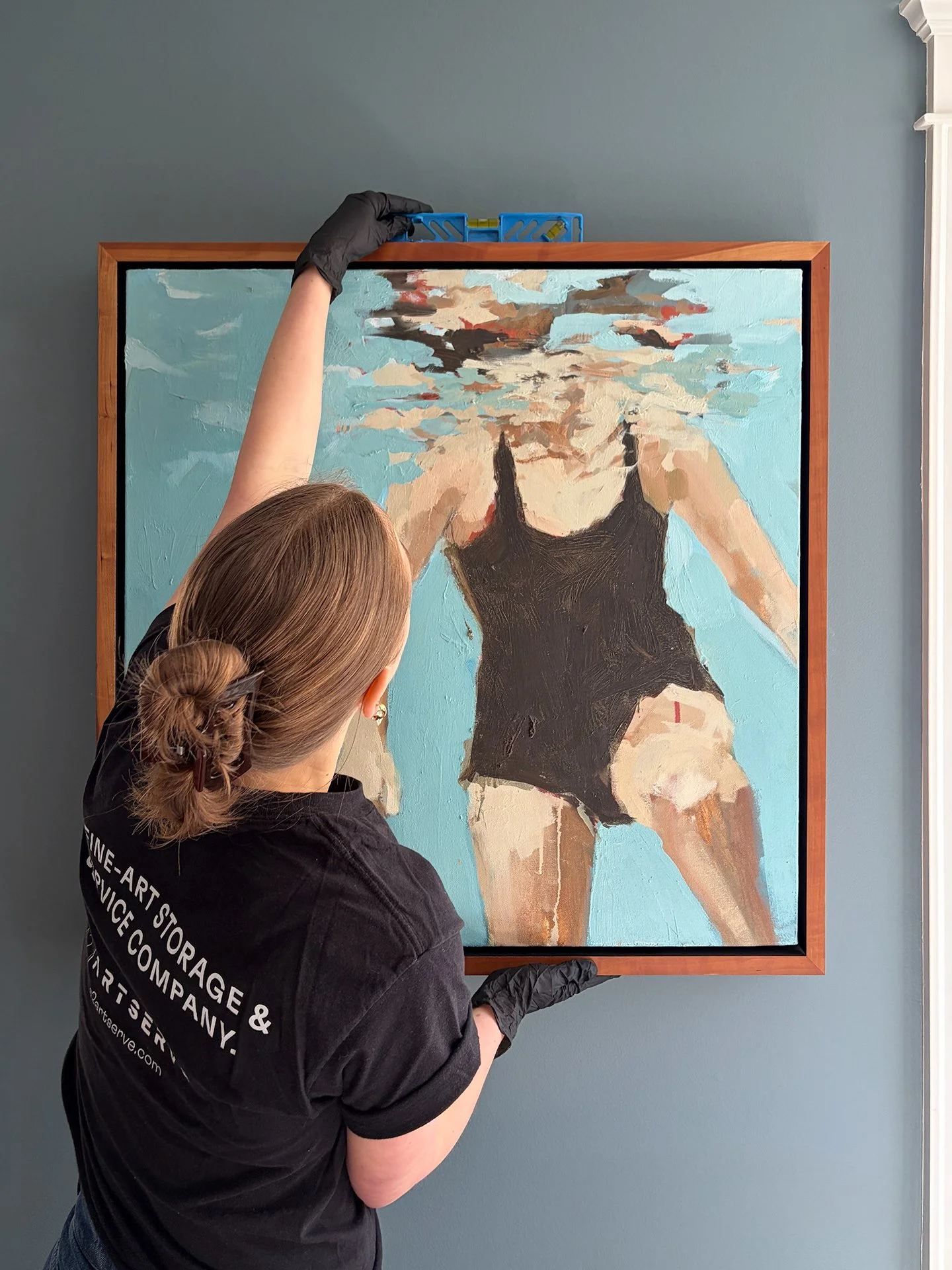 Artserve fine art handler technician installing an artwork in a client's home.