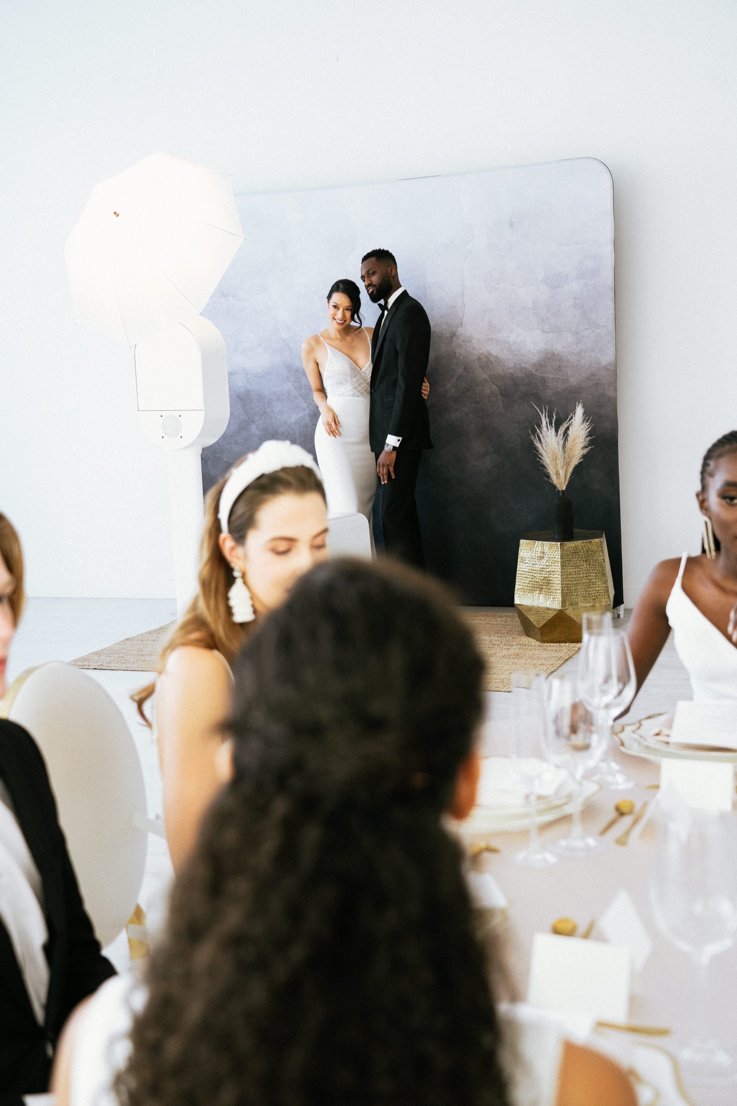A bride and groom take a photo in their wedding reception photo booth