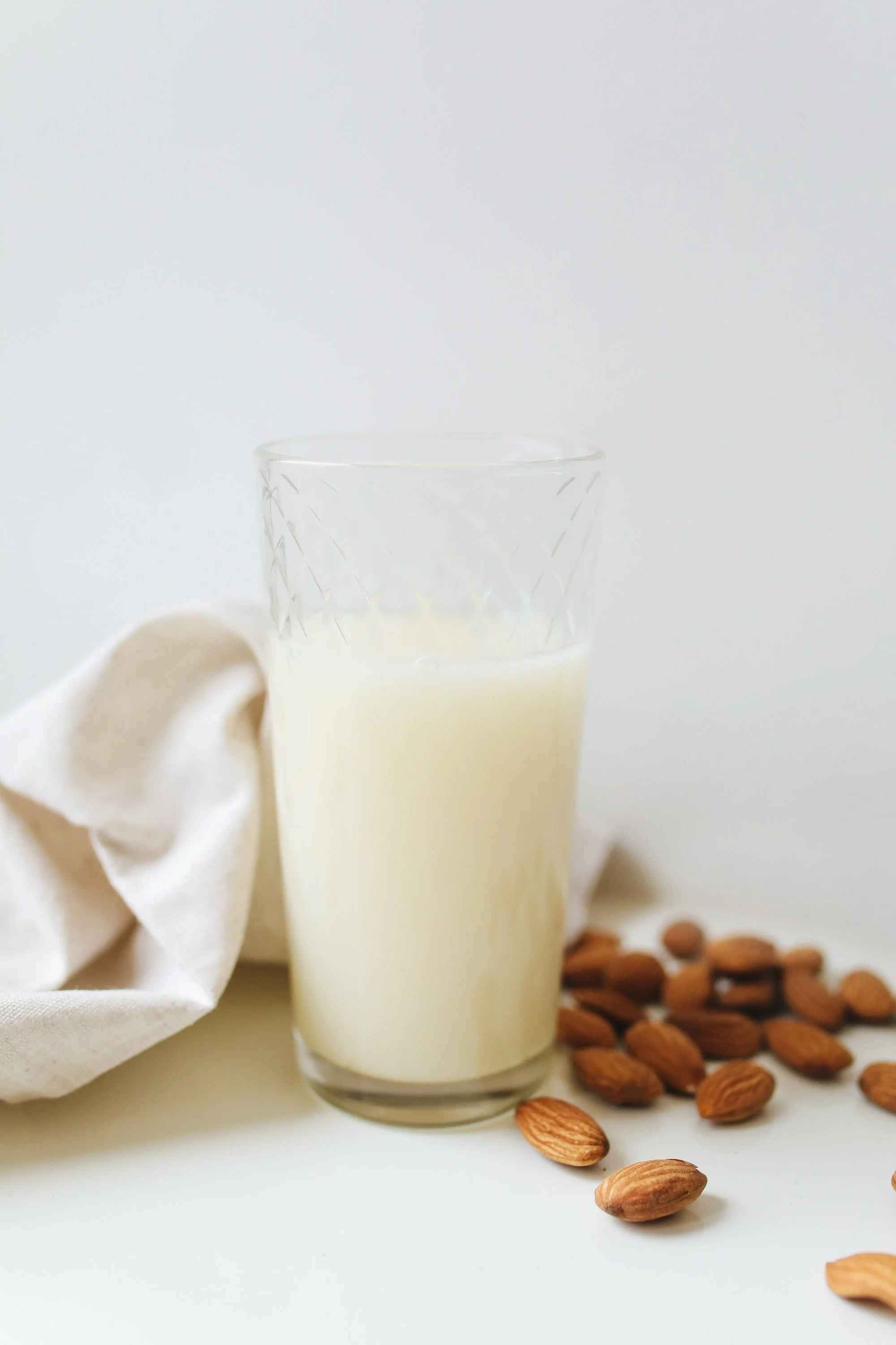 Almond Milk in a Glass with Almonds on the Side