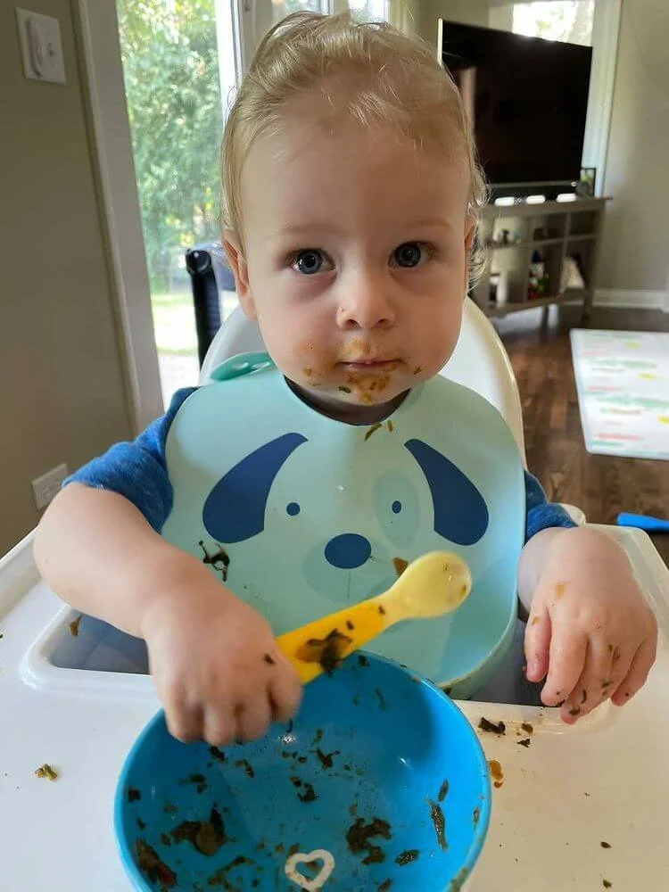 11-month-old baby boy eating spinach