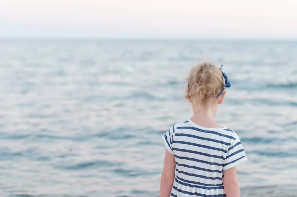 Female child staring at ocean