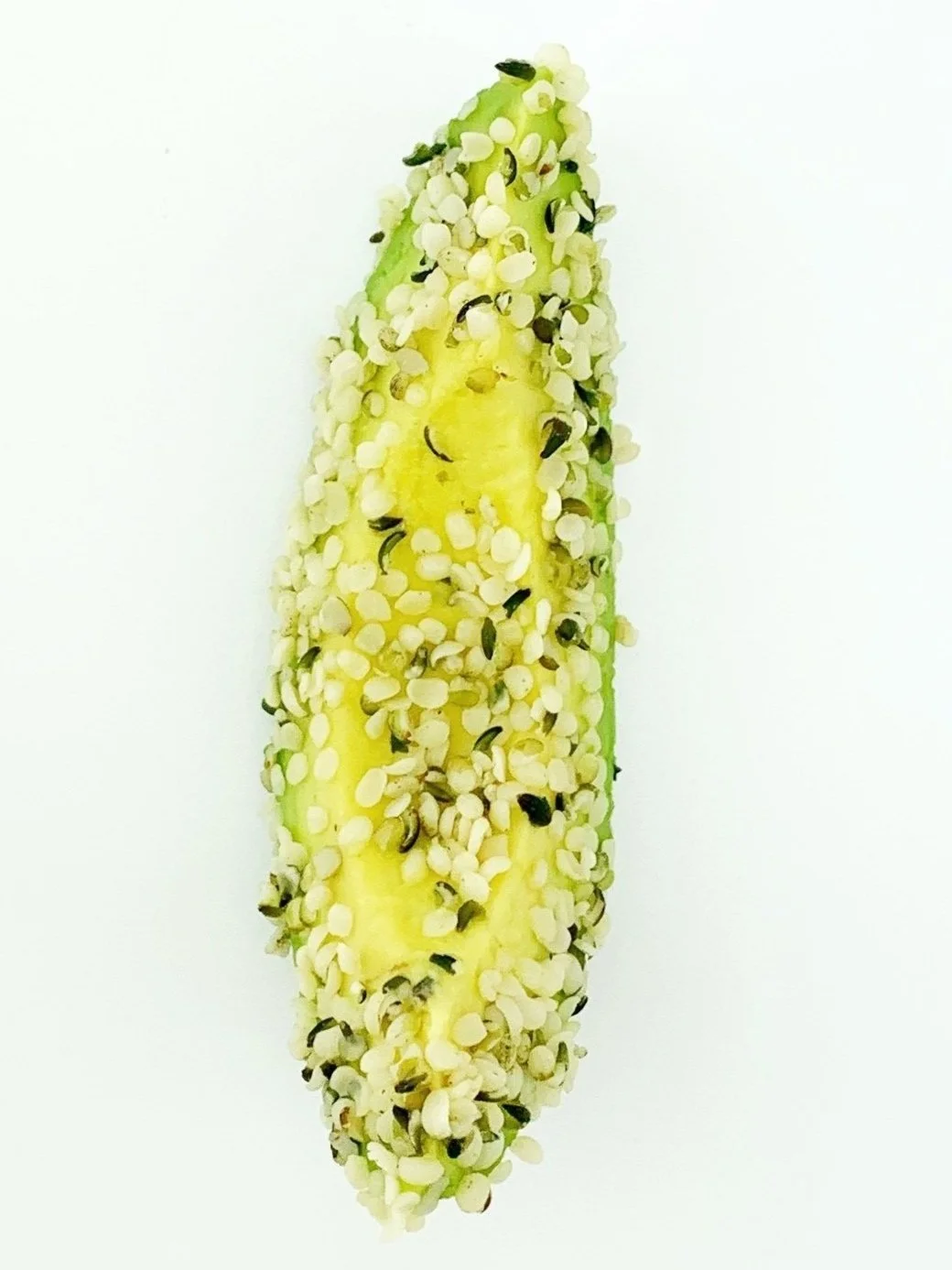 Avocado wedge rolled in hemp seeds