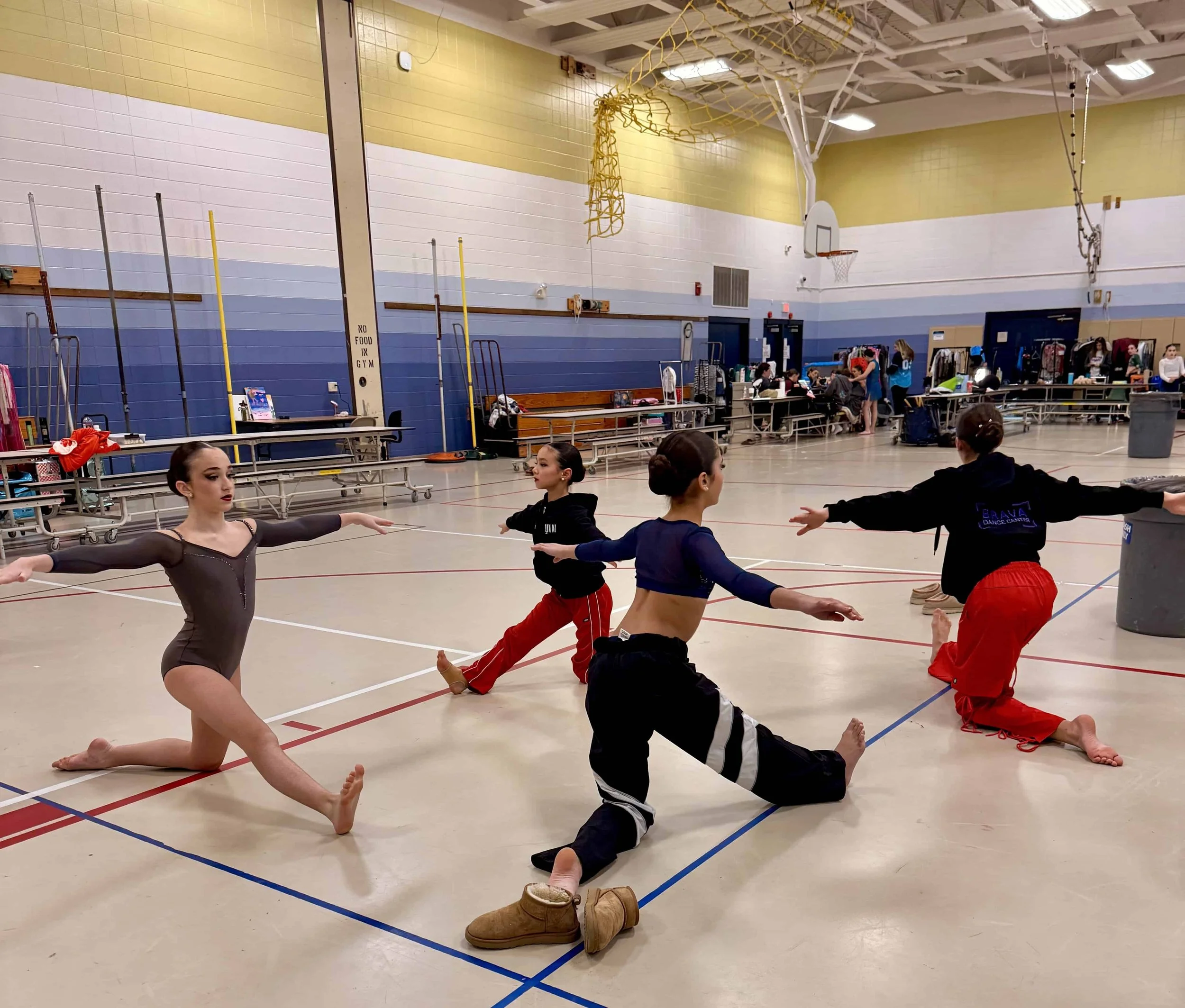 Female gymnasts and dancers preparing for a meet