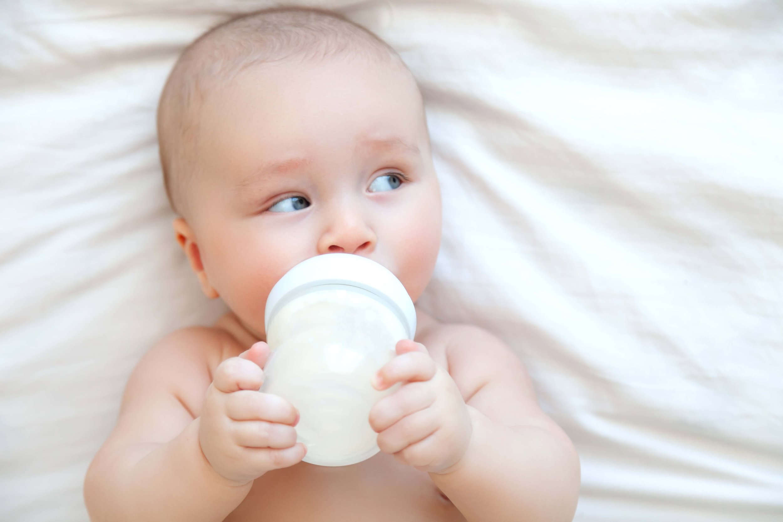 Infant drinking formula, holding bottle