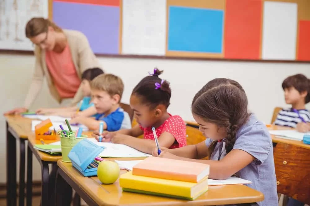Young pupils and teacher in classroom