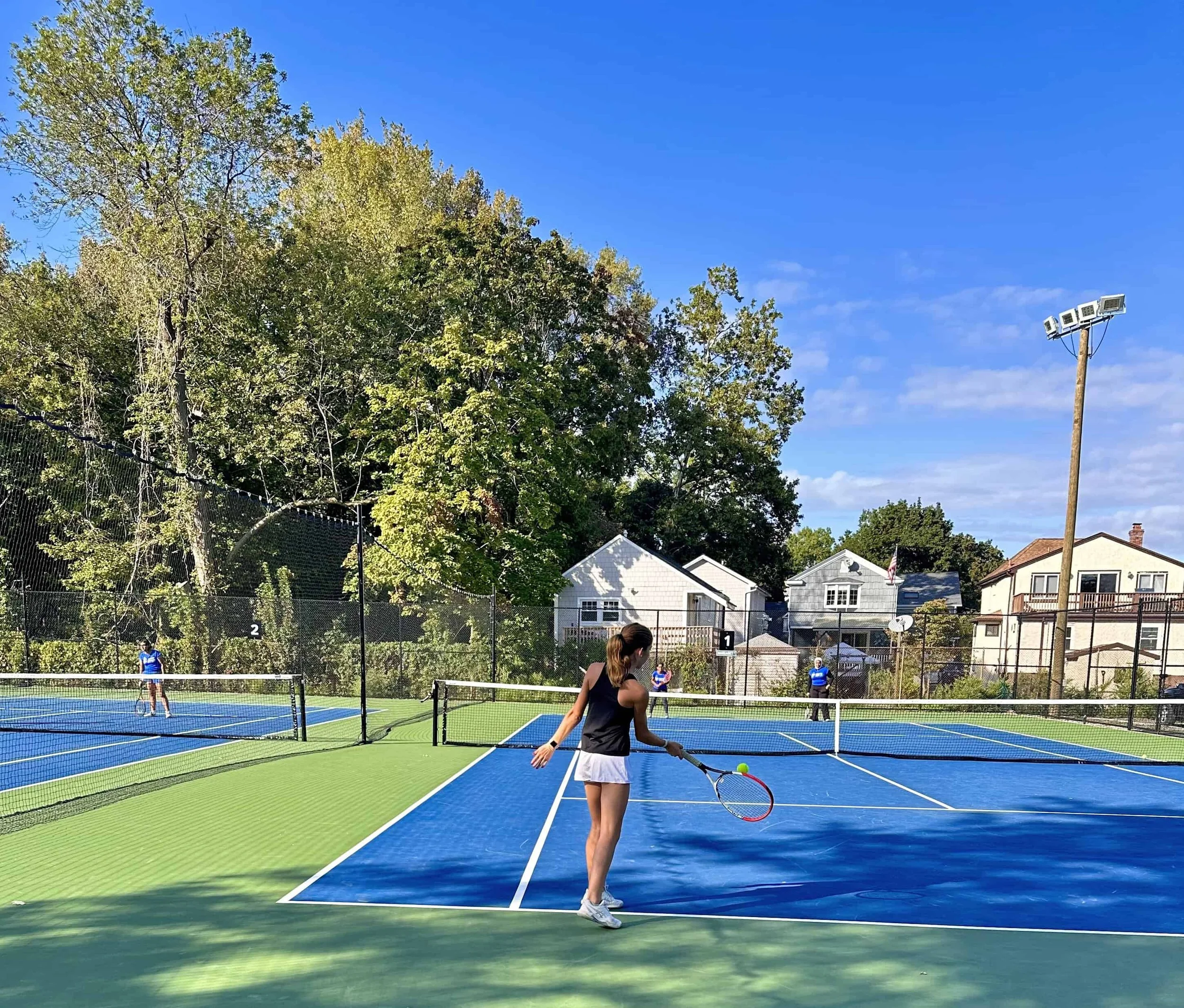 Adolescent female on tennis court with raquet