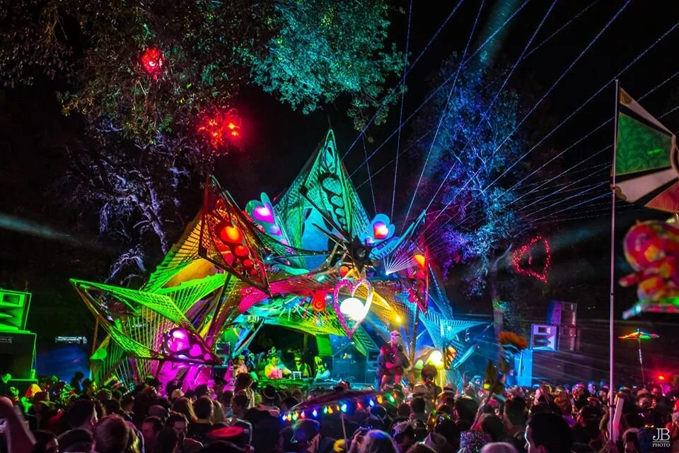 View of the singular stage at night when the festival is in full swing and 5000 attendees roam the dance floor and other installations.