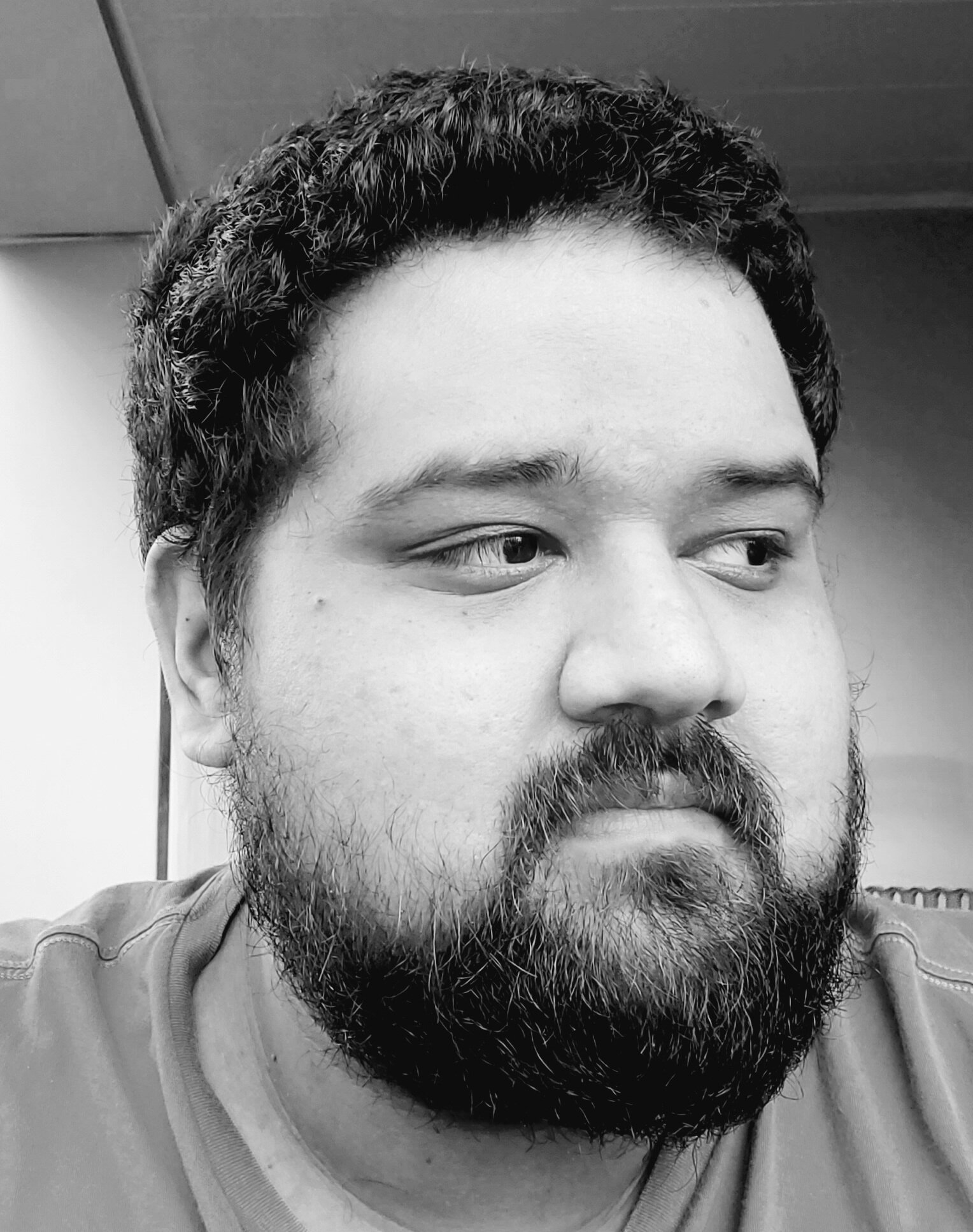Black and white photo of a person with a beard looking to the side
