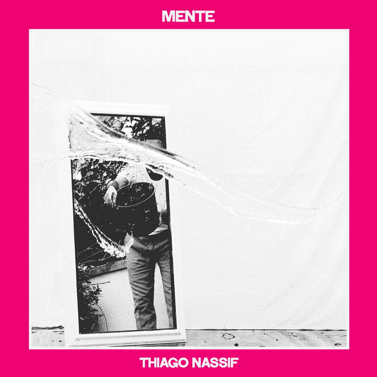 Black and white photograph of a person holding a pot, reflected in a mirror with water splashing, surrounded by a pink border with text 'MENTE Thiago Nassif'.