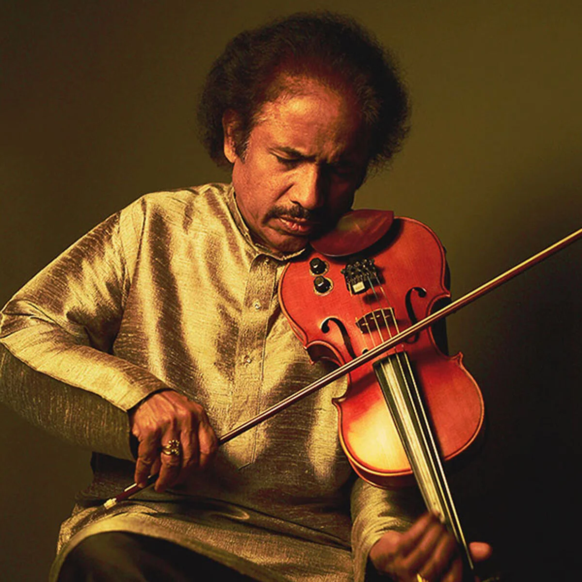 Man playing a violin passionately, wearing a traditional silk outfit, with a focused expression.
