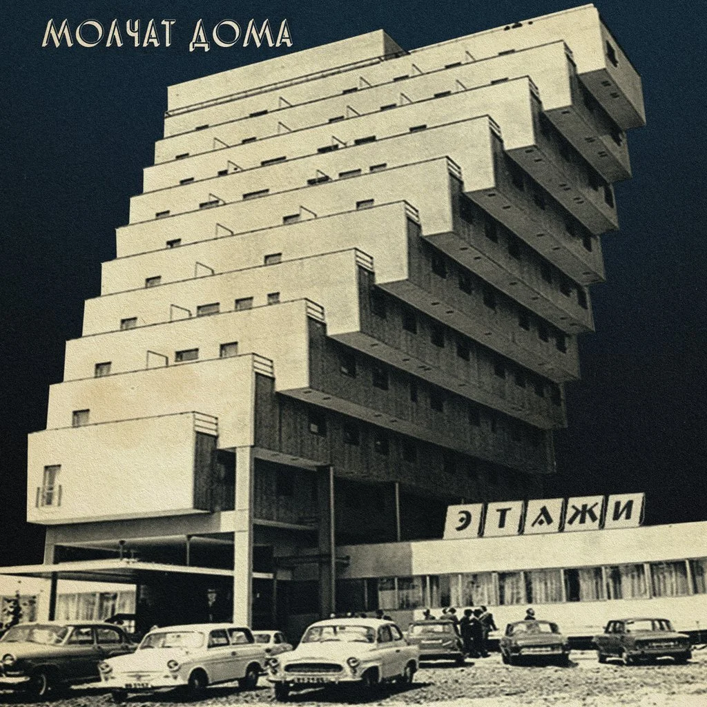 Retro architecture with cars at the base, text in Cyrillic on top and building facade.