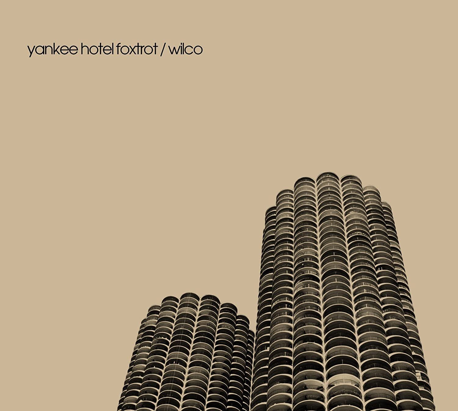 Cover of Wilco's album 'Yankee Hotel Foxtrot' featuring two cylindrical skyscrapers against a beige background.