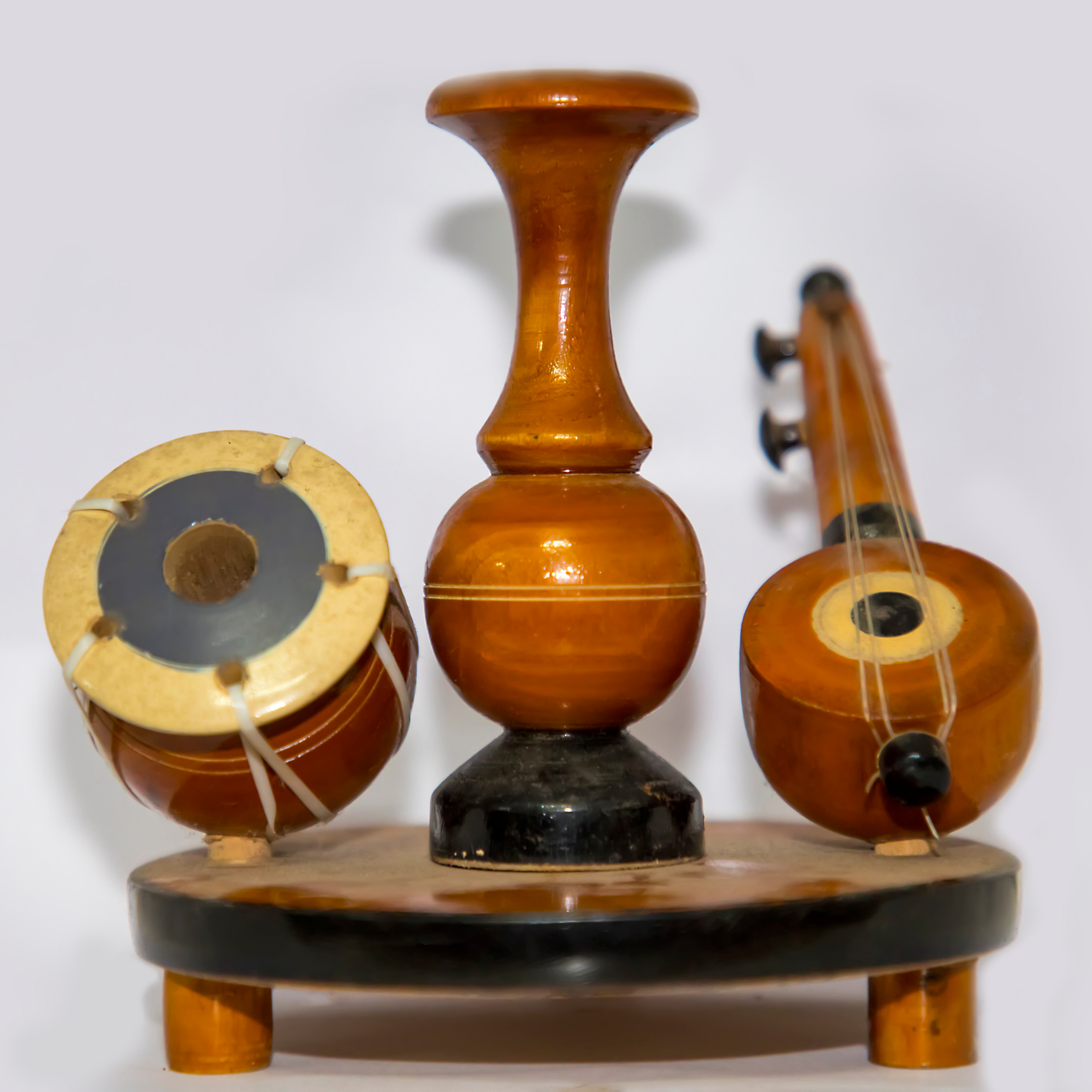 Wooden miniature Indian musical instruments displayed together on a stand.