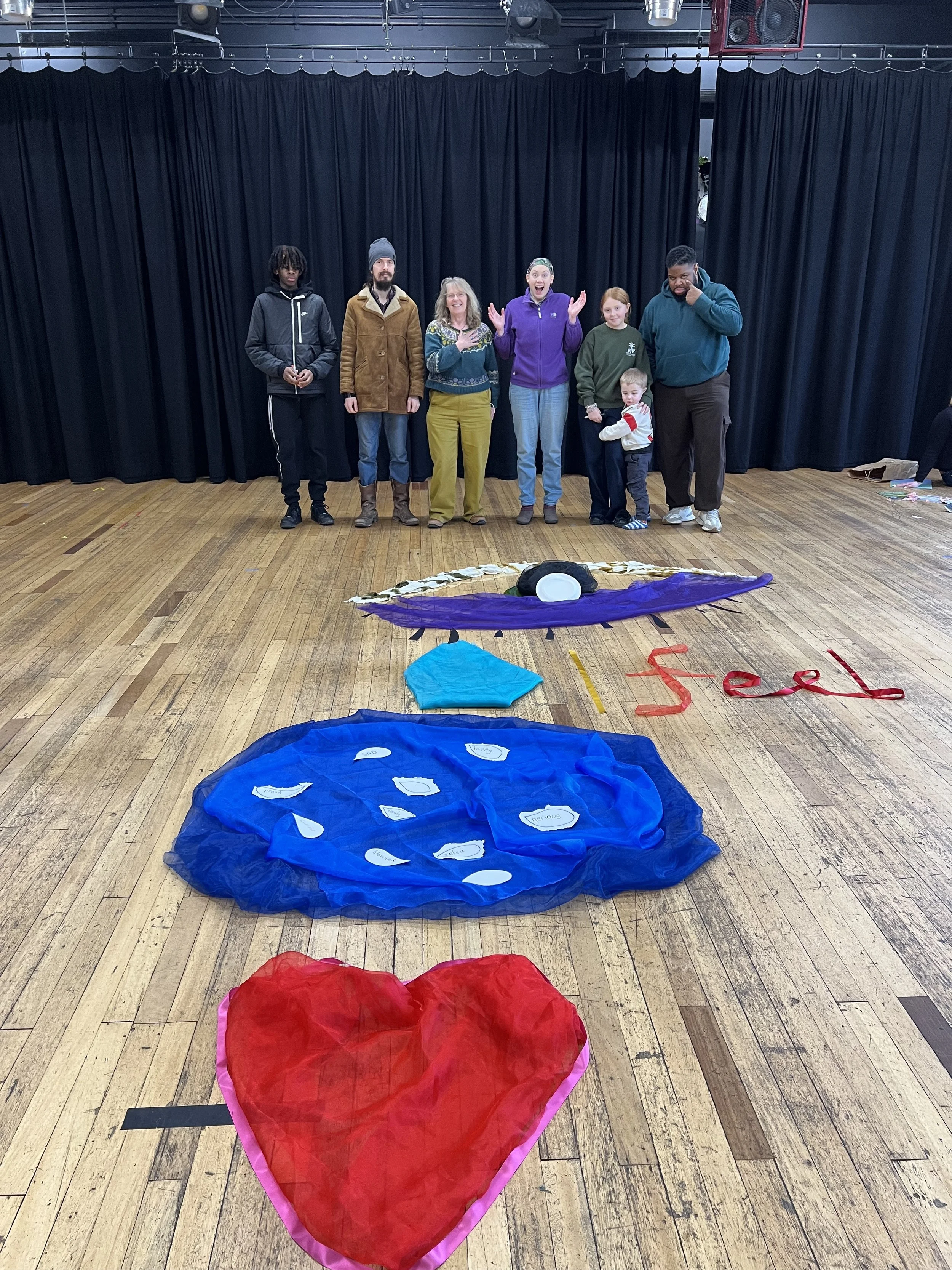 Some of the participants in The Deeper Meaning of My Voice with their floor art design