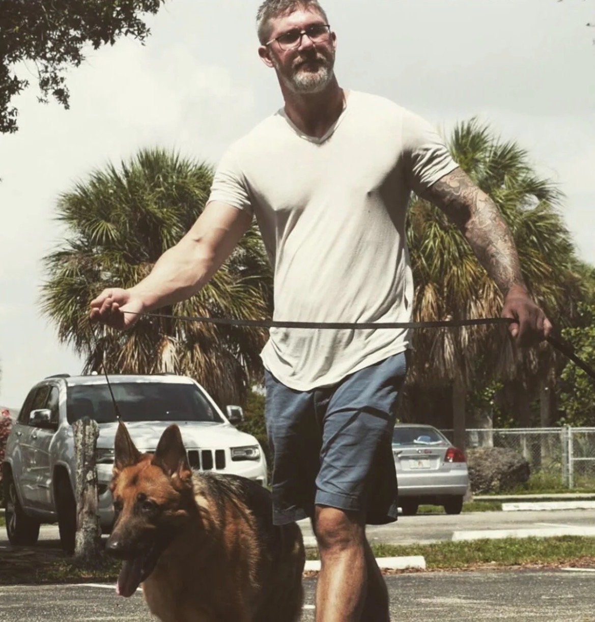 Dog trainer working on desensitization techniques with a reactive rescue dog outdoors in Broward, Florida.