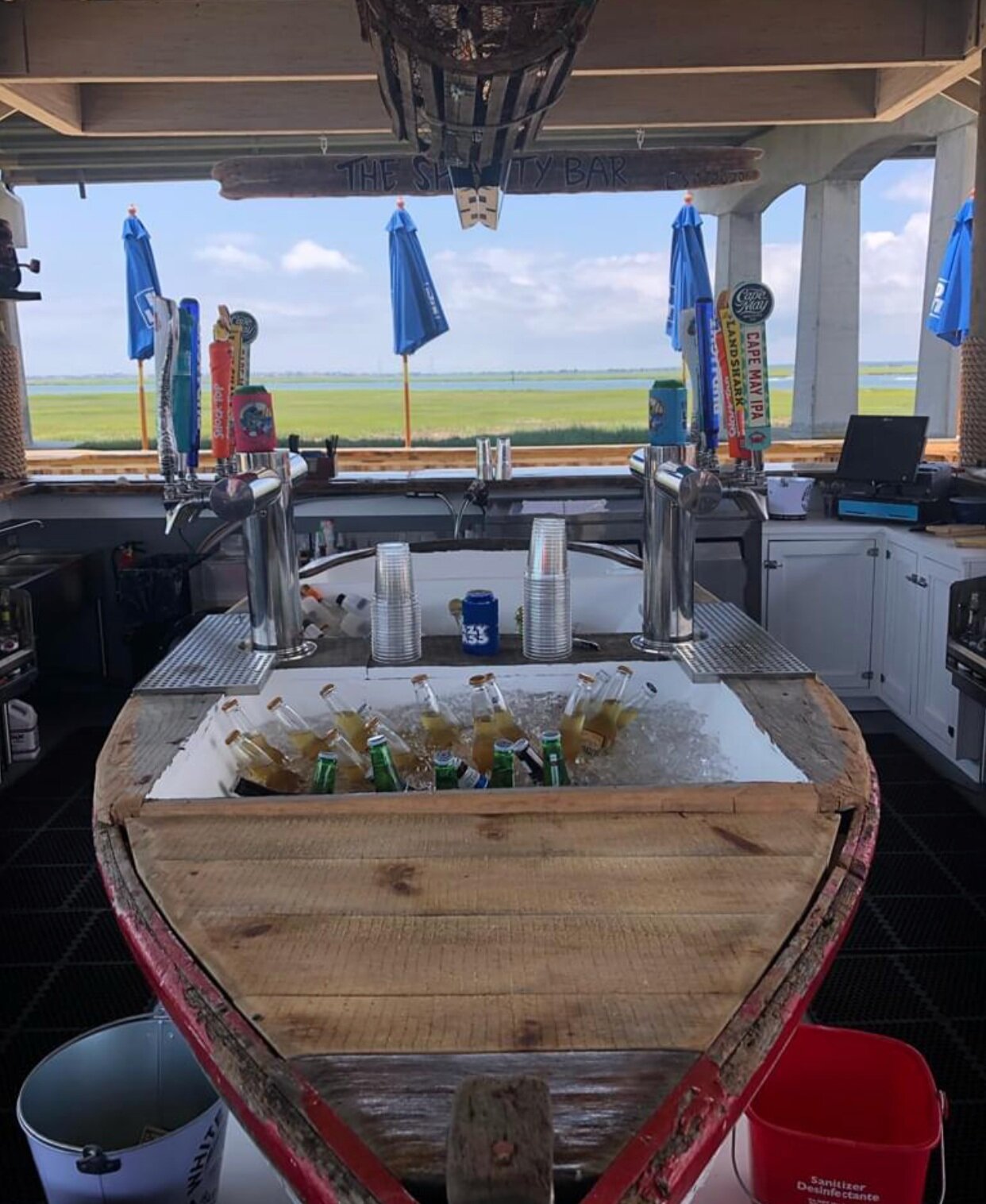 The outdoor bar features an old rowboat fitted with beer taps and lobster trap light fixtures.