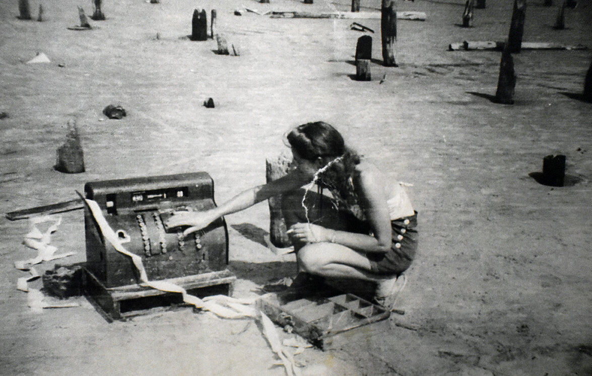 A woman with a cash register from a shop in town.