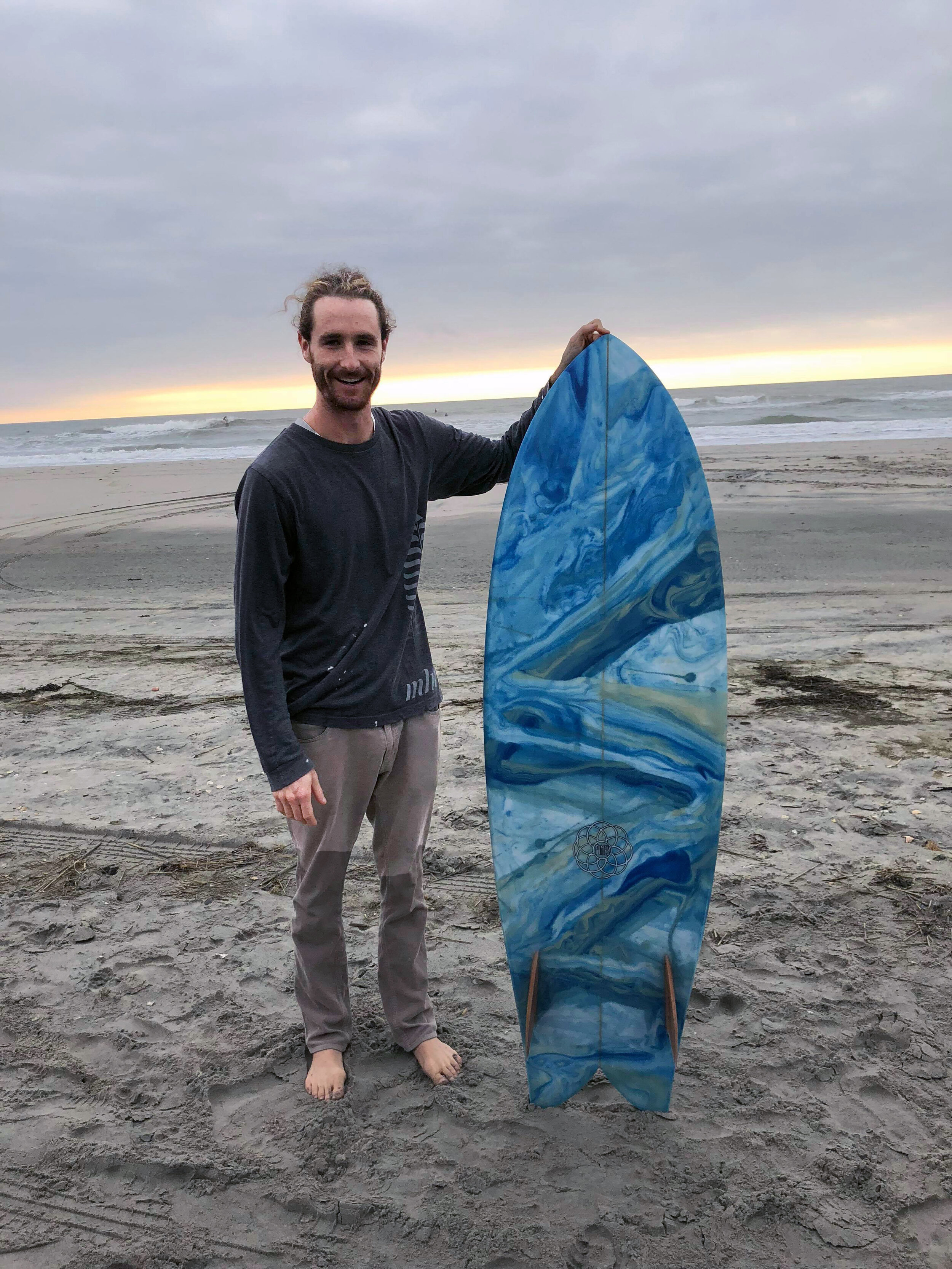 Carney with board he donated to the Fins for Friends contest featuring his resin swirl technique.