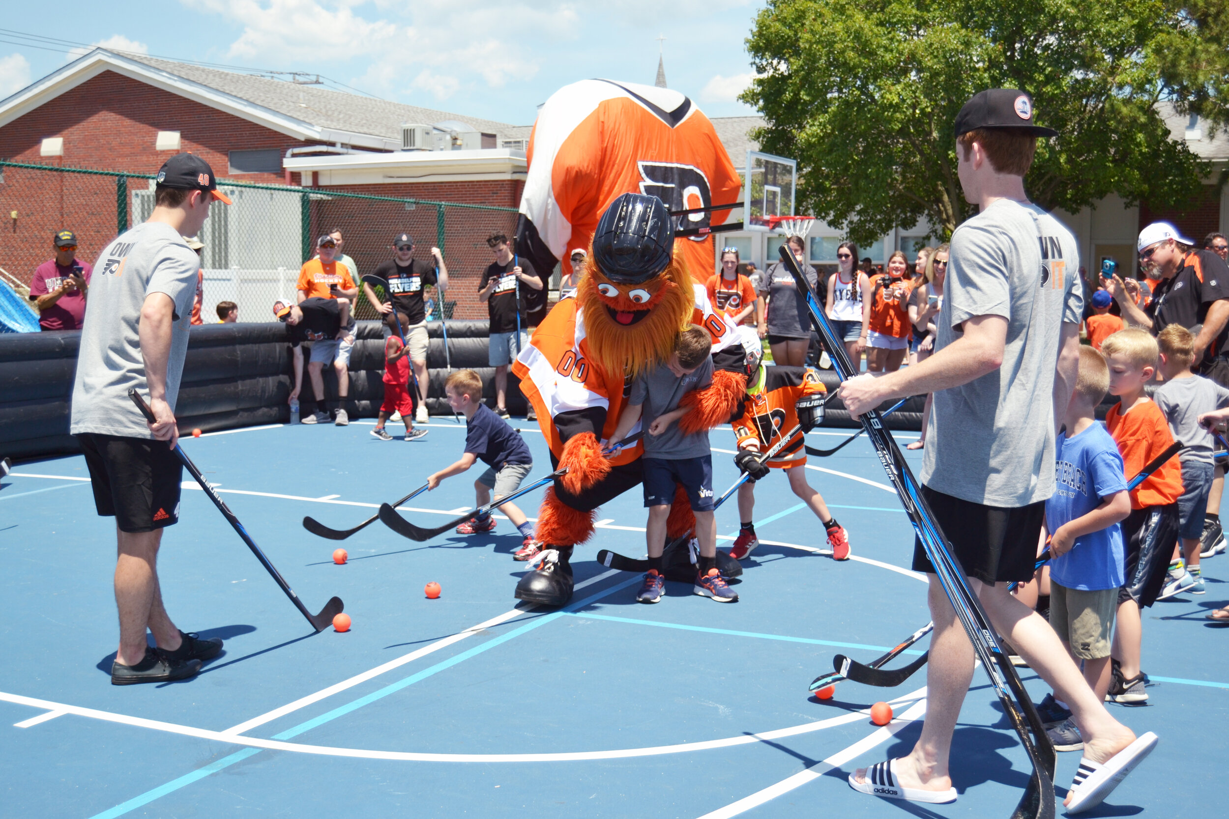 Flyers mascot Gritty assists a young fan during the hockey clinic.