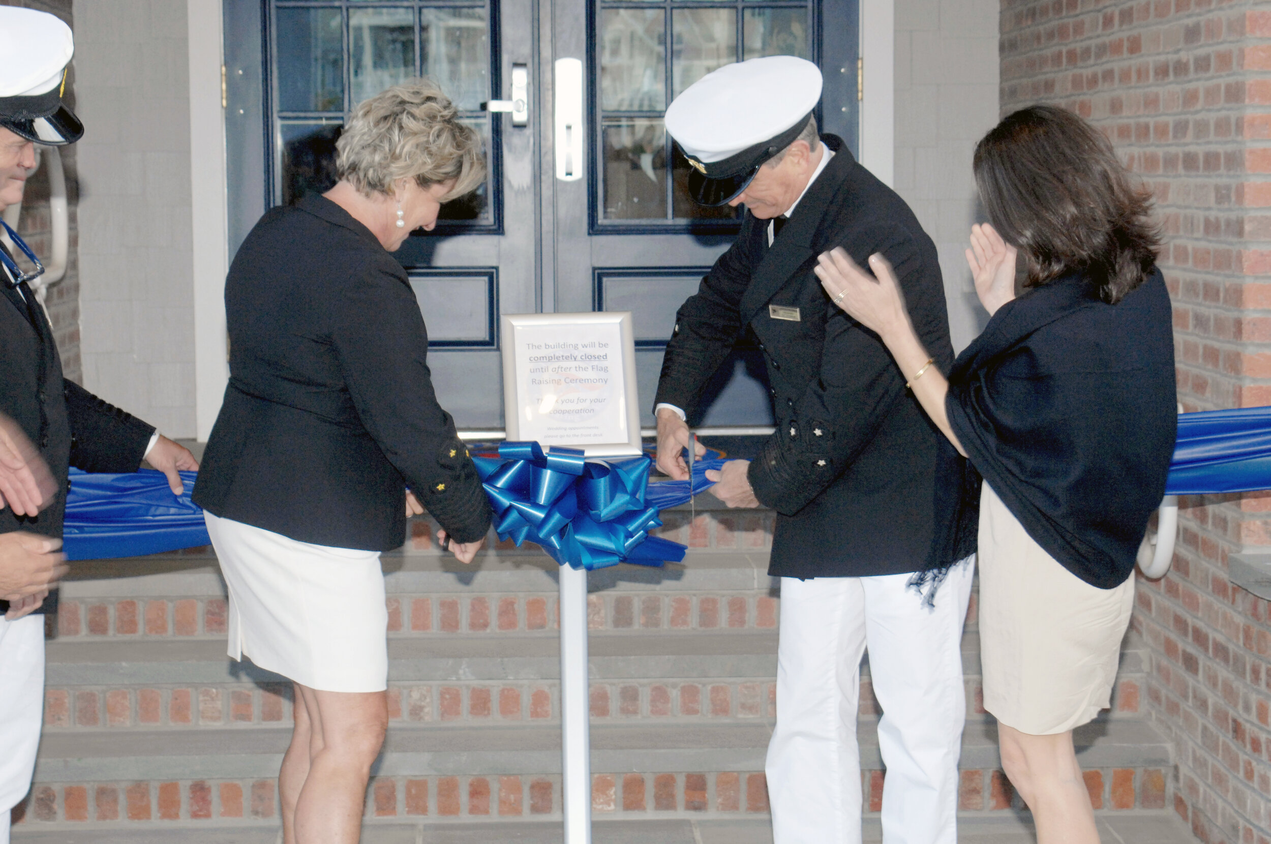 Commodore Lynn Grimaldi and Chairman of the Board Dan Magee cut the ribbon during the YCSH 2019 Flag Raising.