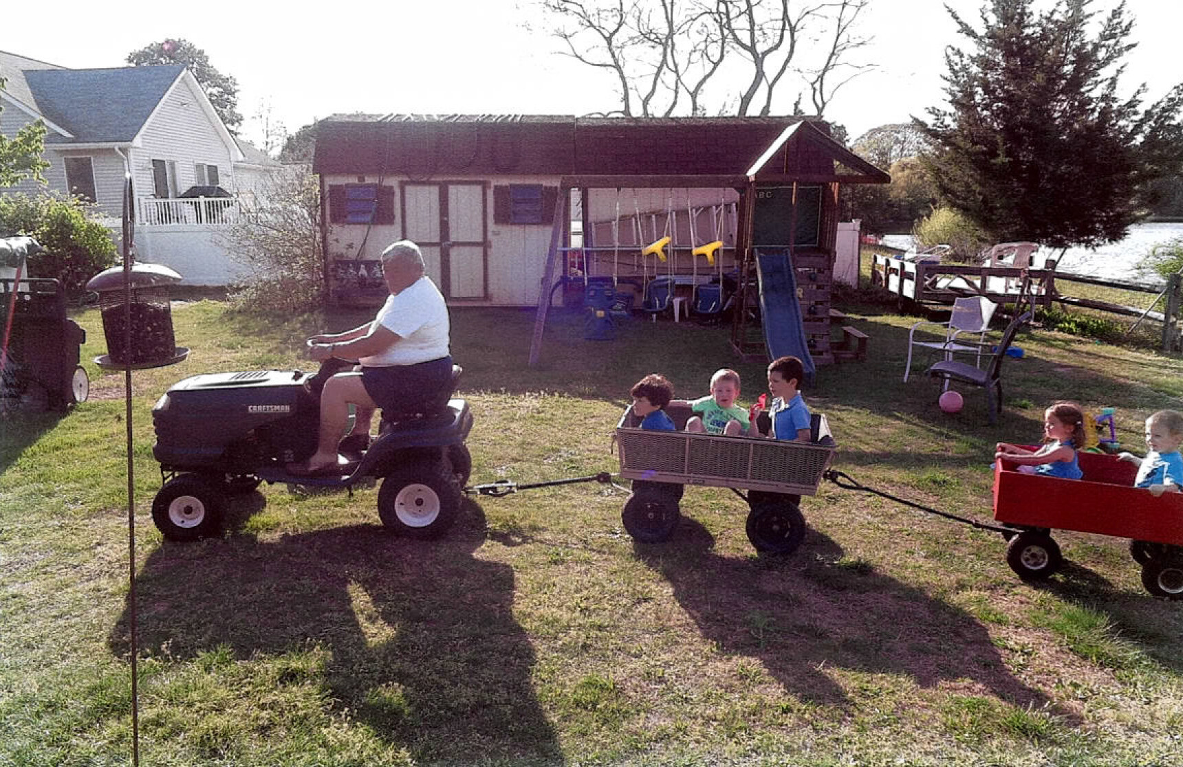 Lou Taylor pulling his grandchildren in wagons.