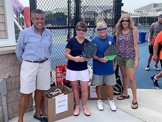 Posing with food from the pickleball outreach are Tim Clay, Pat Allex, Kim Jackson and Michelle Altenpohl, chair of the YCSH Community Outreach.