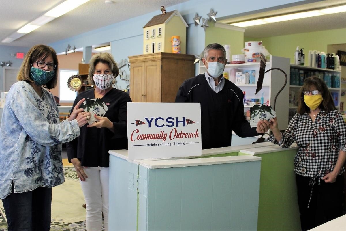 YCSH past commodores Lynn Grimaldi and Tim Clay hand Acme gift cards to Family Promise staff members. The cards were purchased with Easter Parade proceeds.