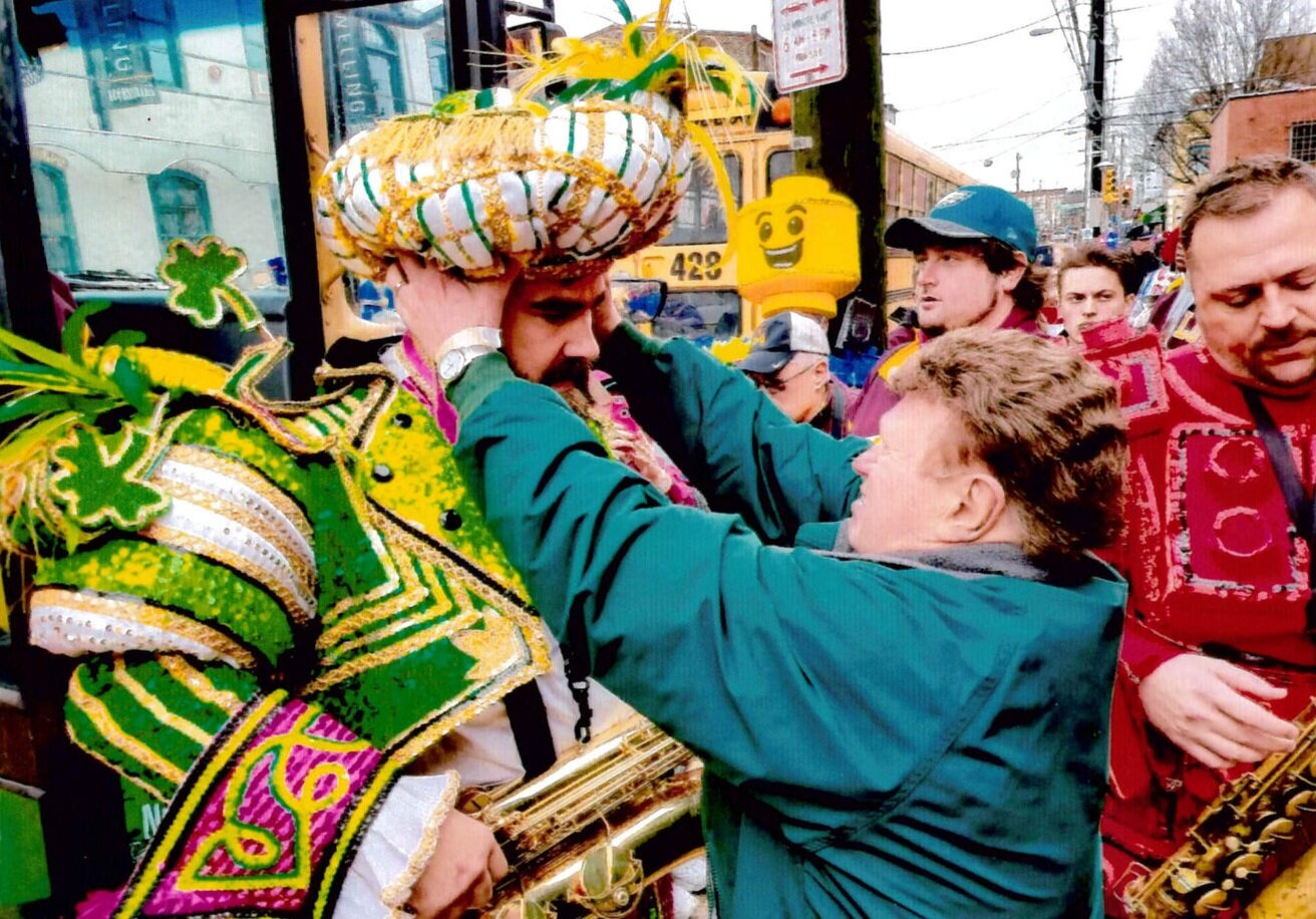 Mummers outfitter Jimmy May positions hat on Eagles’ Jason Kelce for the Super Bowl parade, then poses with him (right). 