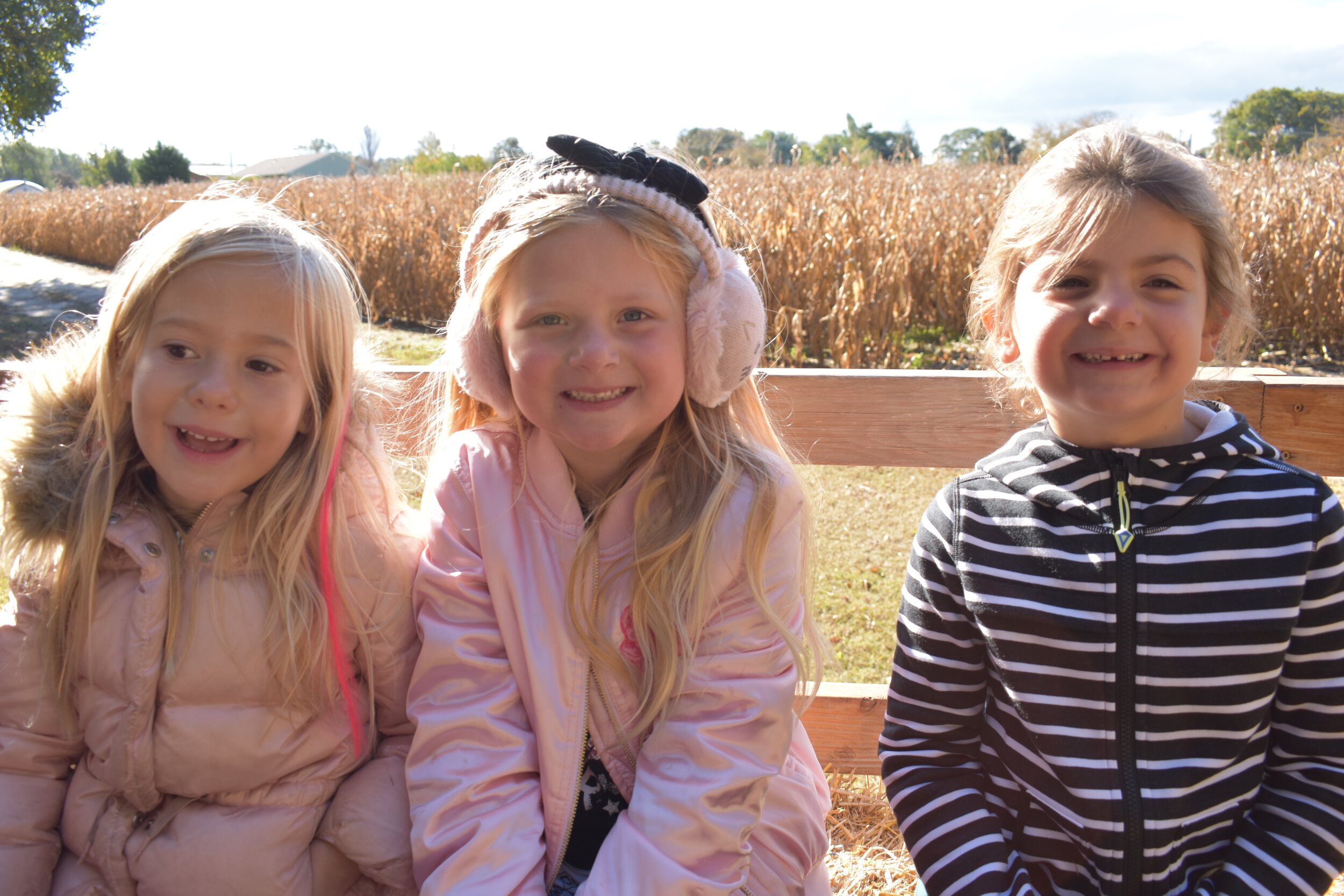 Kindergarteners Willa Simon, Tenli Windsor and Ava Barnoski visit the pumpkin patch.