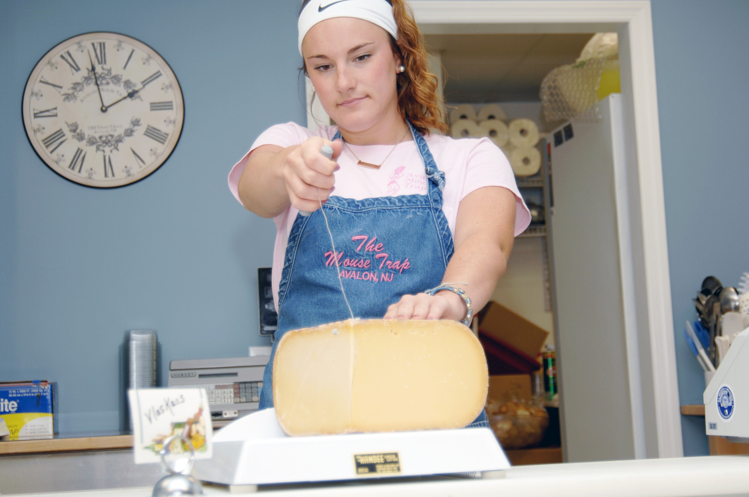 Vicky Tumasz cuts one of the 90 fine international cheeses offered by the Avalon Mouse Trap.
