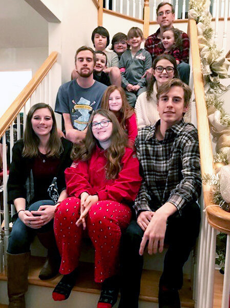 Twelve of Jeff Pierson’s grandchildren pose on stairs.