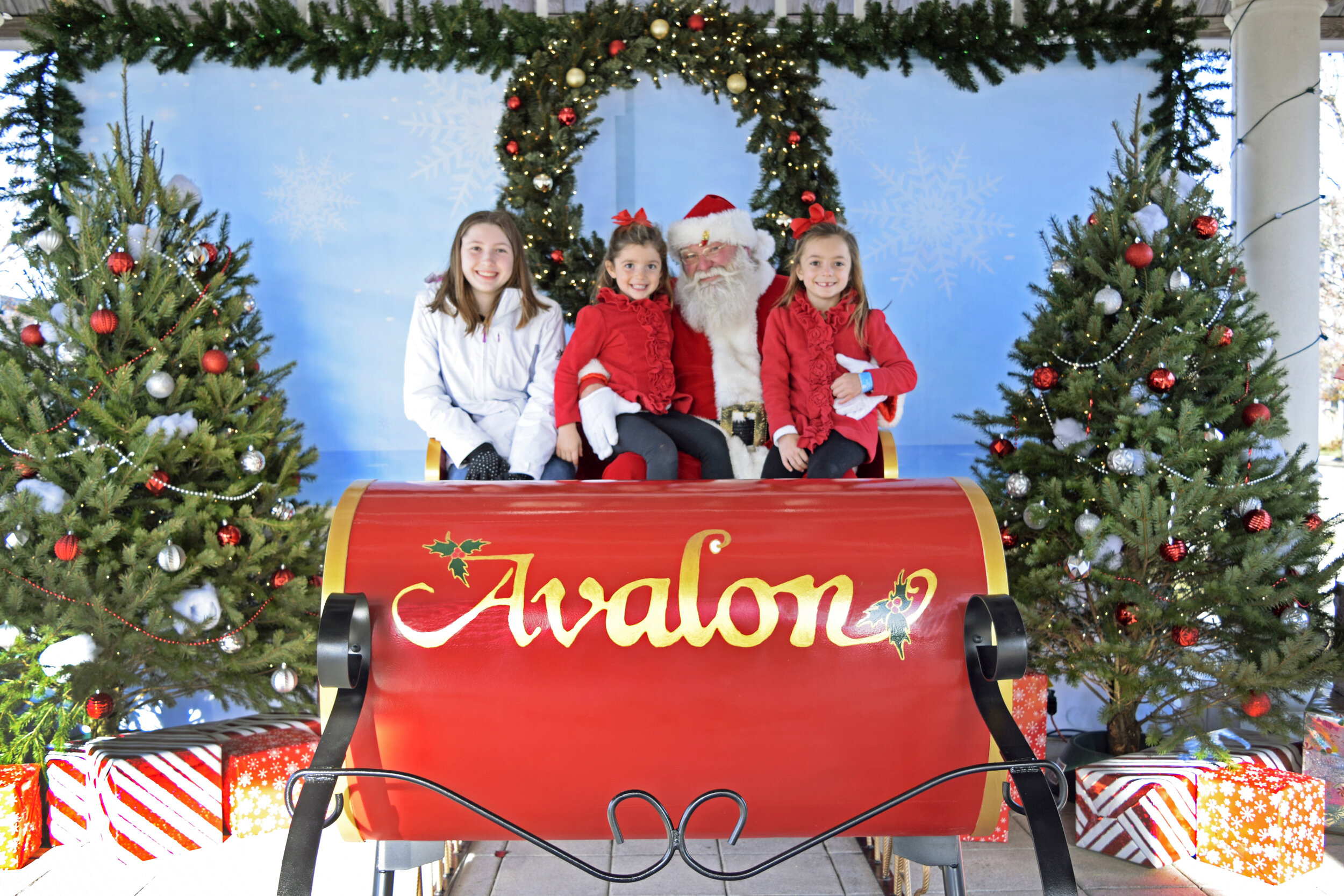 Kaylee, Brynn, and Keira Cunningham pose  with Santa at Avalon’s Snowfest Saturday.